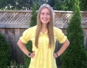 girl in yellow dress smiling outside